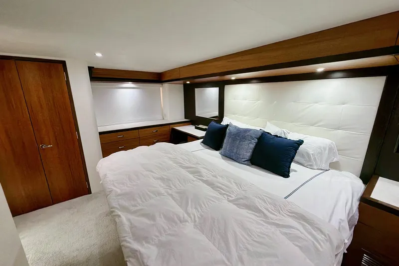 2024 Refit Yacht Photos Pics Luxurious bedroom interior of 2011 Hatteras 60 Motor Yacht with elegant wood finishes.
