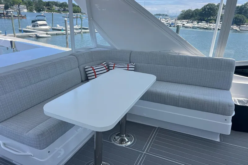 2024 Refit Yacht Photos Pics Luxurious seating area on a 2011 Hatteras yacht with marina view.