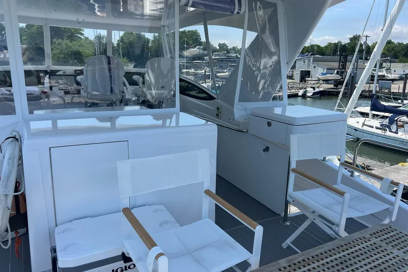 2024 Refit Yacht Photos Pics 2011 Hatteras yacht deck with white seating and marina view.