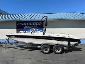 2001 Reinell 203 boat on trailer, parked outside a marine shop.