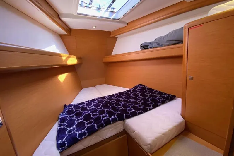 Motu Yacht Photos Pics Cozy cabin interior of 2013 Jeanneau 57 yacht with skylight and wooden finish.