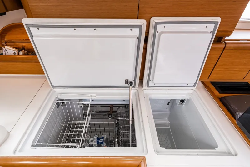 Motu Yacht Photos Pics Interior view of 2013 Jeanneau 57 yacht showing open storage compartments.