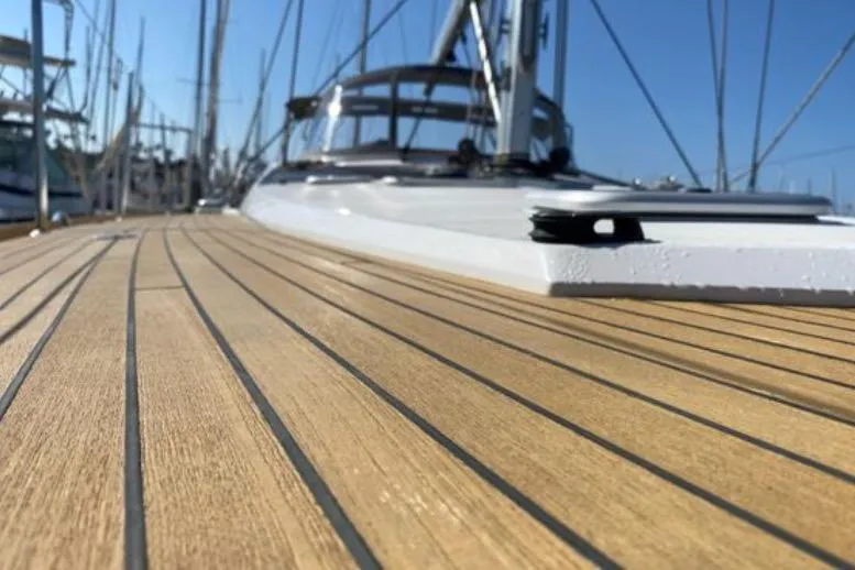 Motu Yacht Photos Pics 2013 Jeanneau 57 yacht deck with sleek wooden finish and clear blue sky.