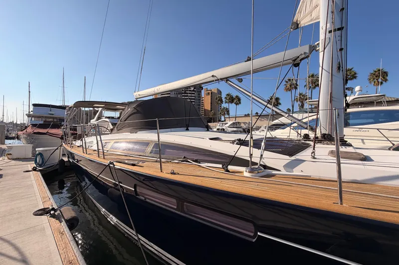 Motu Yacht Photos Pics 2013 Jeanneau 57 yacht docked at marina under clear blue sky.
