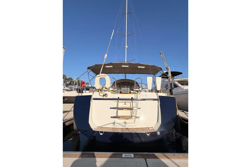 Motu Yacht Photos Pics 2013 Jeanneau 57 yacht docked at marina, rear view with clear blue sky.