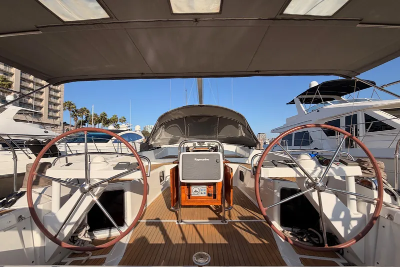 Motu Yacht Photos Pics 2013 Jeanneau 57 yacht cockpit with dual steering wheels, docked in a marina.