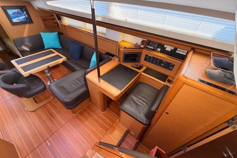 Motu Yacht Photos Pics Luxurious interior of a 2013 Jeanneau 57 yacht with elegant wood finishes and seating.
