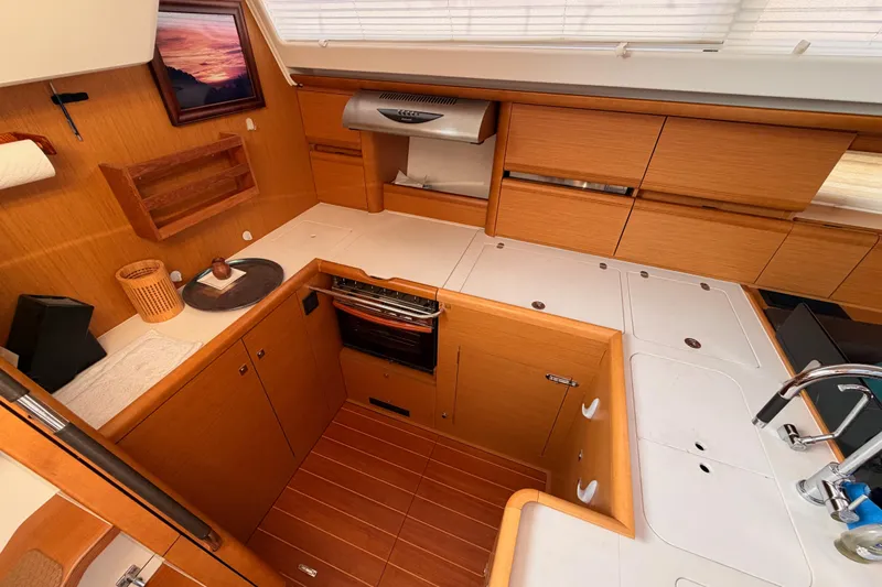 Motu Yacht Photos Pics Luxurious 2013 Jeanneau 57 yacht kitchen with wood cabinetry and modern appliances.
