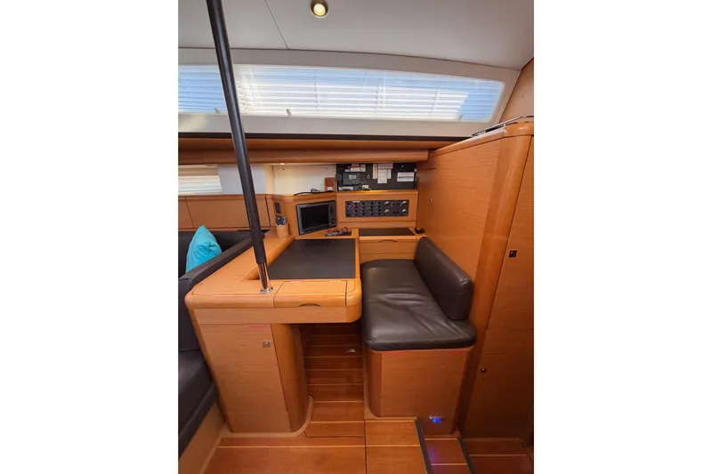 Motu Yacht Photos Pics Interior of 2013 Jeanneau 57 yacht with navigation station and seating area.