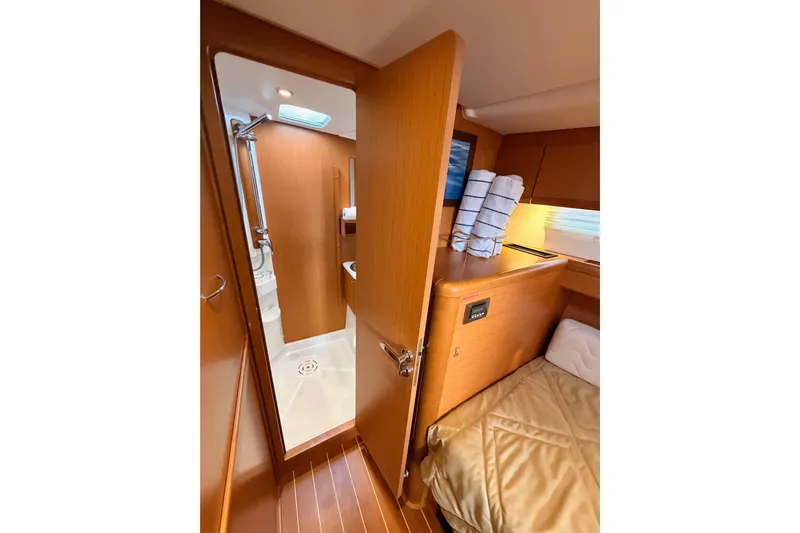 Motu Yacht Photos Pics Interior of 2013 Jeanneau 57 yacht showing cozy cabin and bathroom.