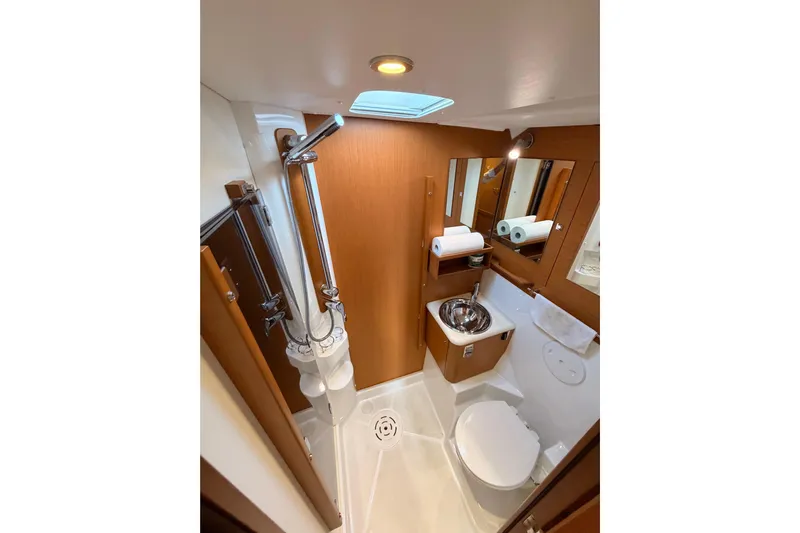Motu Yacht Photos Pics Luxurious bathroom in 2013 Jeanneau 57 yacht with modern fixtures and wooden accents.