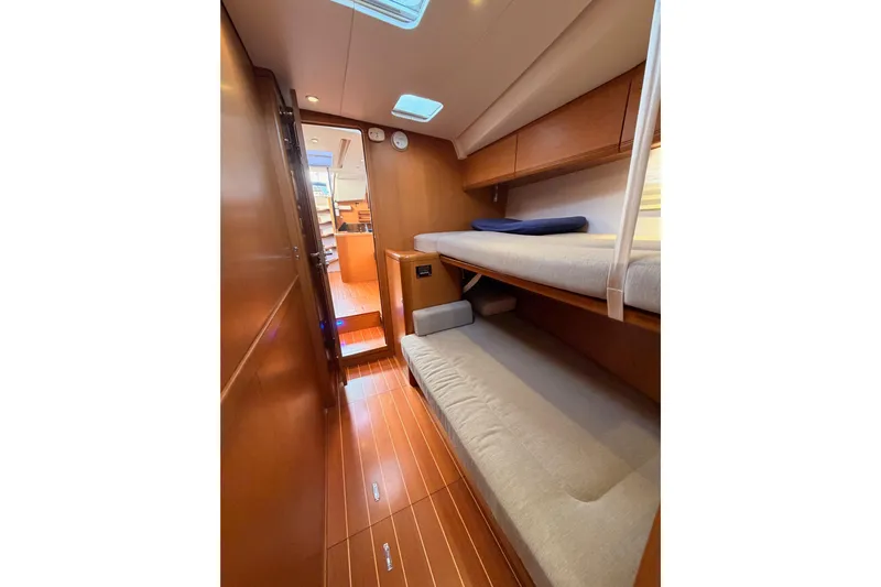 Motu Yacht Photos Pics 2013 Jeanneau 57 yacht interior with wooden flooring and bunk beds.