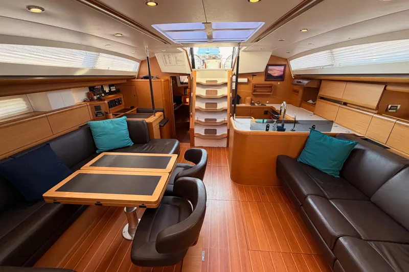 Motu Yacht Photos Pics Luxurious interior of a 2013 Jeanneau 57 yacht with elegant wood finishes and modern amenities.