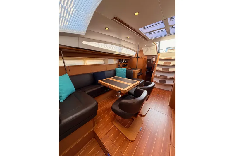 Motu Yacht Photos Pics Luxurious interior of 2013 Jeanneau 57 yacht with elegant seating and wooden flooring.