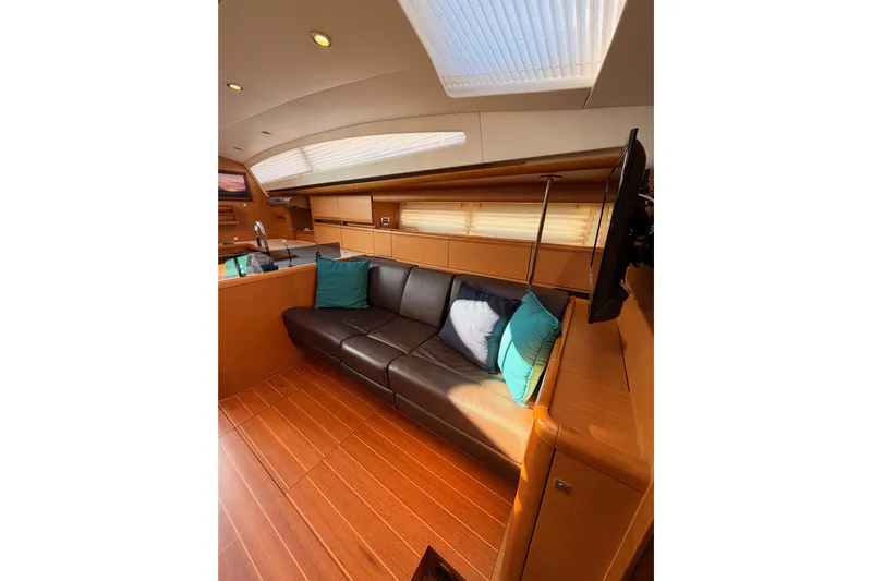 Motu Yacht Photos Pics Luxurious interior of 2013 Jeanneau 57 yacht with leather seating and wooden finishes.