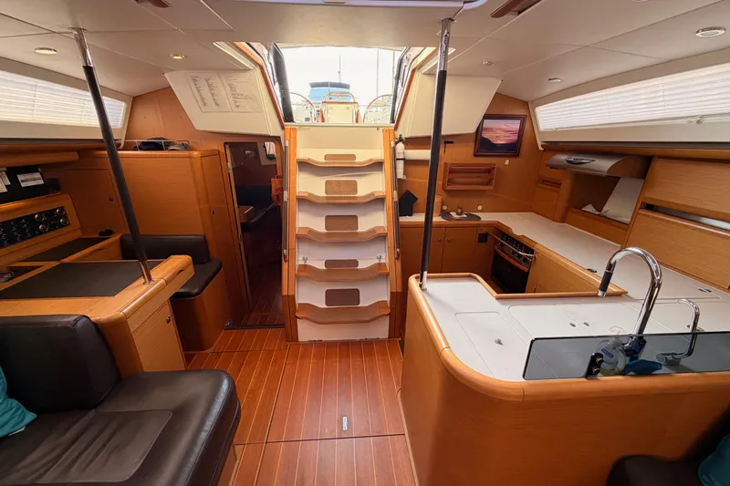 Motu Yacht Photos Pics Luxurious interior of a 2013 Jeanneau 57 yacht with modern kitchen and seating area.