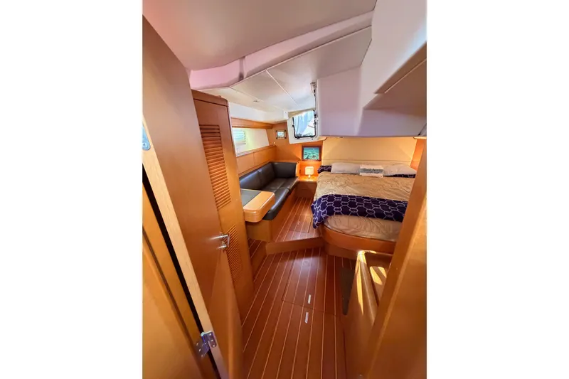 Motu Yacht Photos Pics Luxurious interior of 2013 Jeanneau 57 yacht with cozy bedroom and seating area.