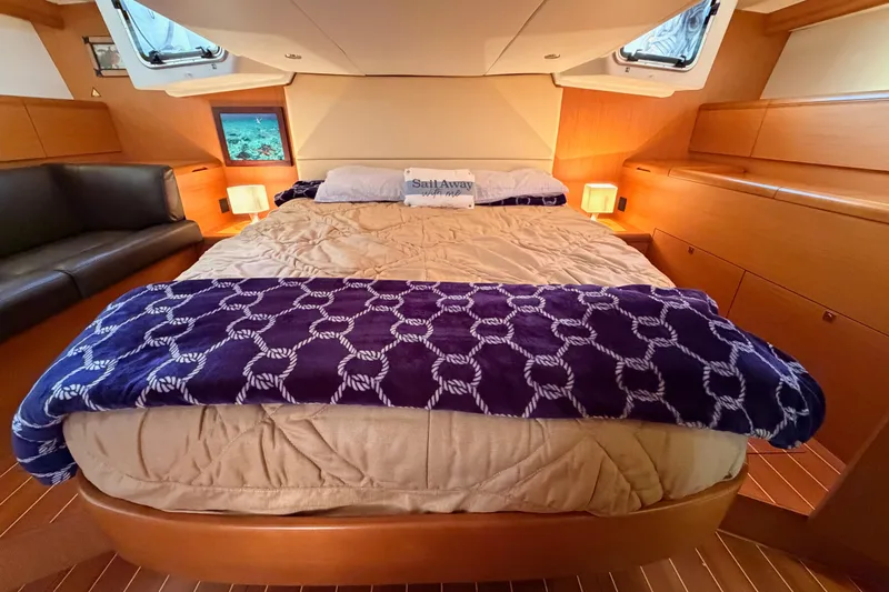 Motu Yacht Photos Pics Luxurious cabin interior of a 2013 Jeanneau 57 yacht with cozy bedding and elegant decor.