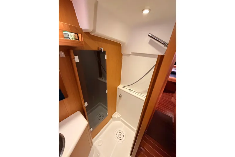Motu Yacht Photos Pics Bathroom interior of 2013 Jeanneau 57 yacht with shower and wooden accents.