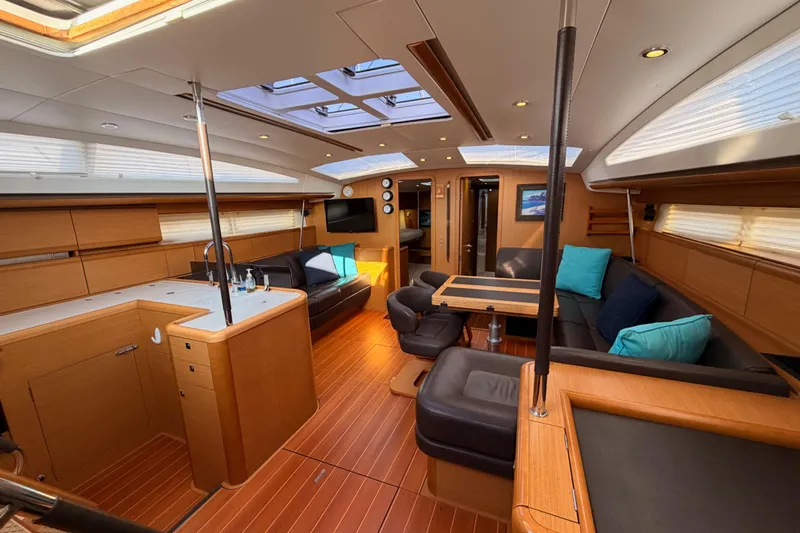 Motu Yacht Photos Pics Luxurious interior of a 2013 Jeanneau 57 yacht with modern furnishings and ample natural light.
