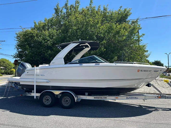  Yacht Photos Pics 2023 Chaparral 270 OSX boat on trailer, parked outdoors.