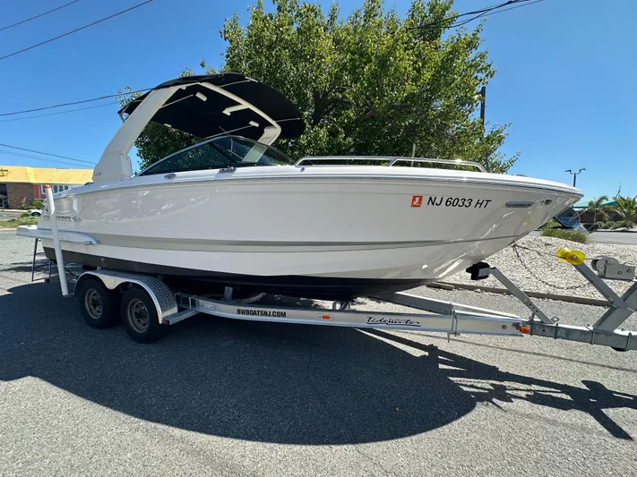  Yacht Photos Pics 2023 Chaparral 270 OSX boat on trailer, parked outdoors.