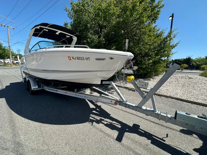  Yacht Photos Pics 2023 Chaparral 270 OSX boat on trailer, parked on a sunny street.