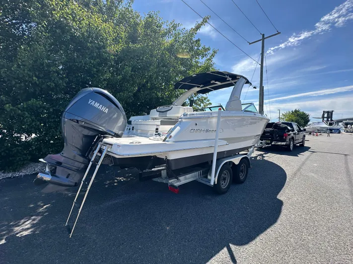  Yacht Photos Pics 2023 Chaparral 270 OSX boat on trailer with Yamaha outboard motor, parked outdoors.