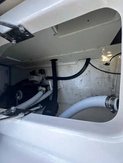  Yacht Photos Pics 2023 Chaparral 270 OSX boat interior compartment with visible hoses and fittings.
