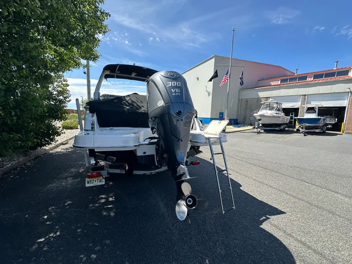  Yacht Photos Pics 2023 Chaparral 270 OSX boat with 300 HP engine, parked outdoors near a marina.