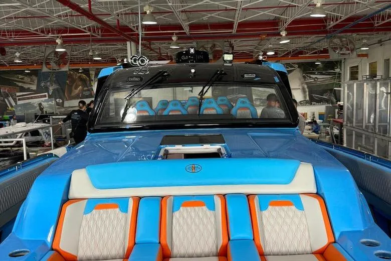  Yacht Photos Pics 2025 Cigarette 52 Thunder boat with vibrant blue and orange seating in a showroom.
