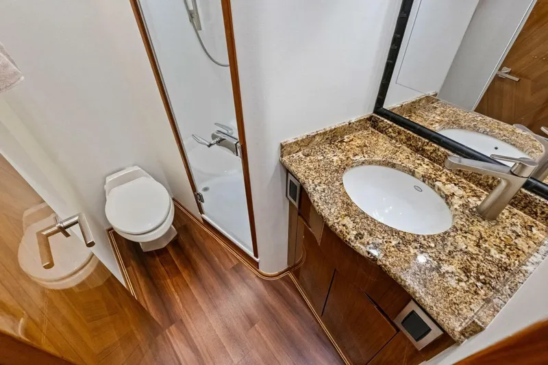 Lady Di Yacht Photos Pics Luxurious bathroom in 2012 Viking 82 Convertible yacht with granite countertop and wooden flooring.