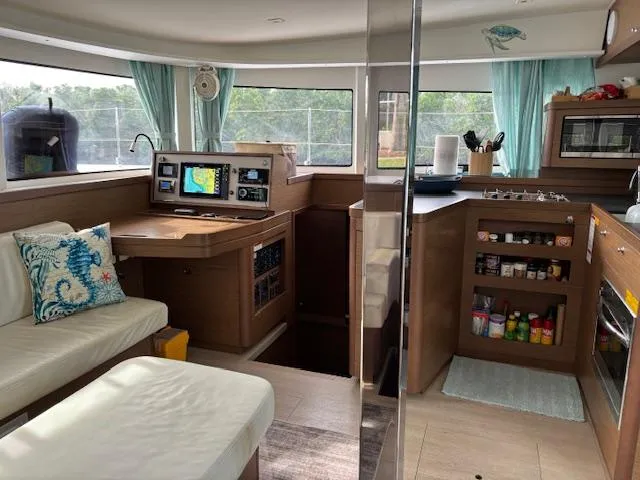 Gone Again Yacht Photos Pics Interior of 2019 Lagoon 42 catamaran with navigation station, kitchen, and seating area.