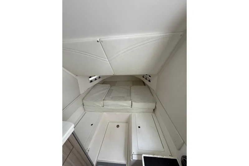  Yacht Photos Pics Interior cabin of 2021 Fountain 43 NX boat with white cushions and storage compartments.