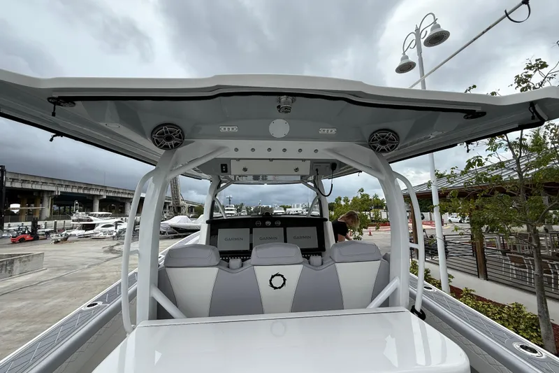  Yacht Photos Pics 2021 Fountain 43 NX boat interior with modern helm and seating under cloudy sky.