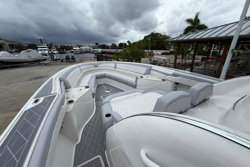  Yacht Photos Pics 2021 Fountain 43 NX boat with luxurious seating, docked under cloudy skies.