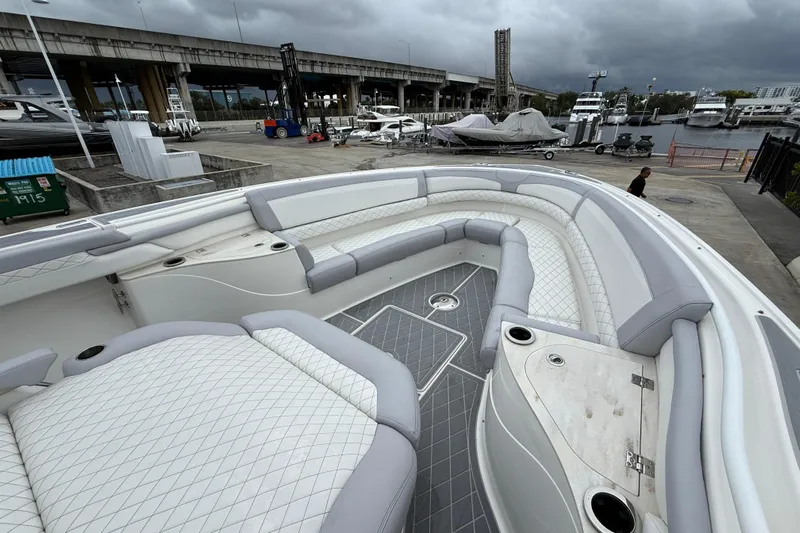  Yacht Photos Pics 2021 Fountain 43 NX boat with spacious seating, docked at a marina under cloudy skies.