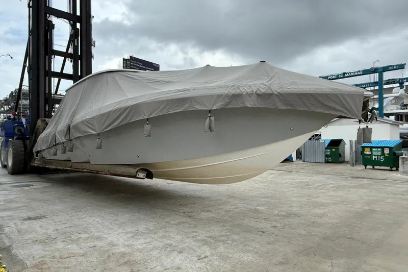 Yacht Photos Pics 2021 Fountain 43 NX boat covered and lifted at marina under cloudy sky.
