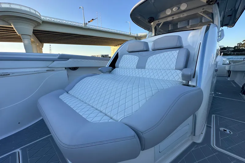  Yacht Photos Pics Luxurious seating on 2021 Fountain 43 NX boat under a bridge, showcasing elegant design.