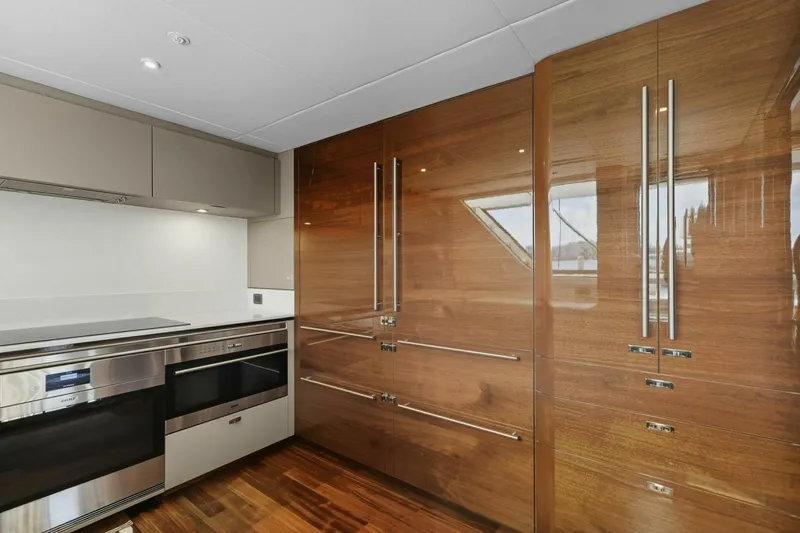 Lady Lion Yacht Photos Pics Luxurious kitchen interior of 2023 Princess X95 yacht with modern appliances and wood finishes.