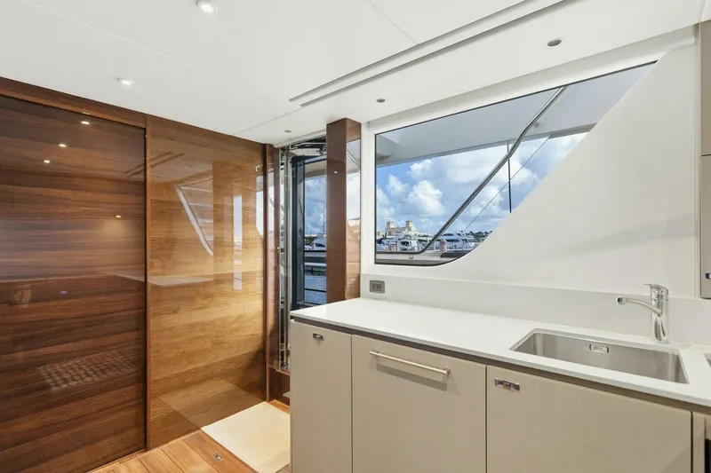 Lady Lion Yacht Photos Pics Luxurious interior of 2023 Princess X95 yacht with sleek wood paneling and modern kitchen.