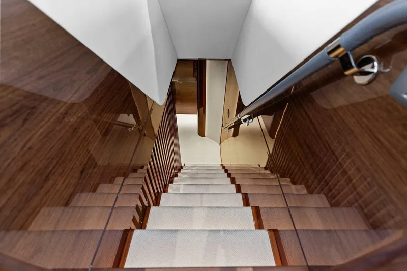 Lady Lion Yacht Photos Pics Luxurious wooden staircase inside 2023 Princess X95 yacht, featuring sleek design and elegant finishes.