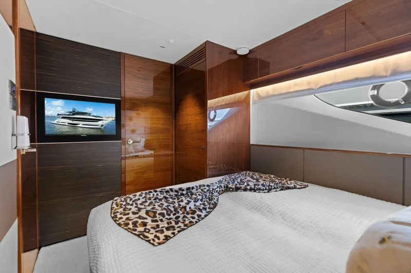 Lady Lion Yacht Photos Pics Luxurious bedroom interior of 2023 Princess X95 yacht with TV and elegant wood finishes.