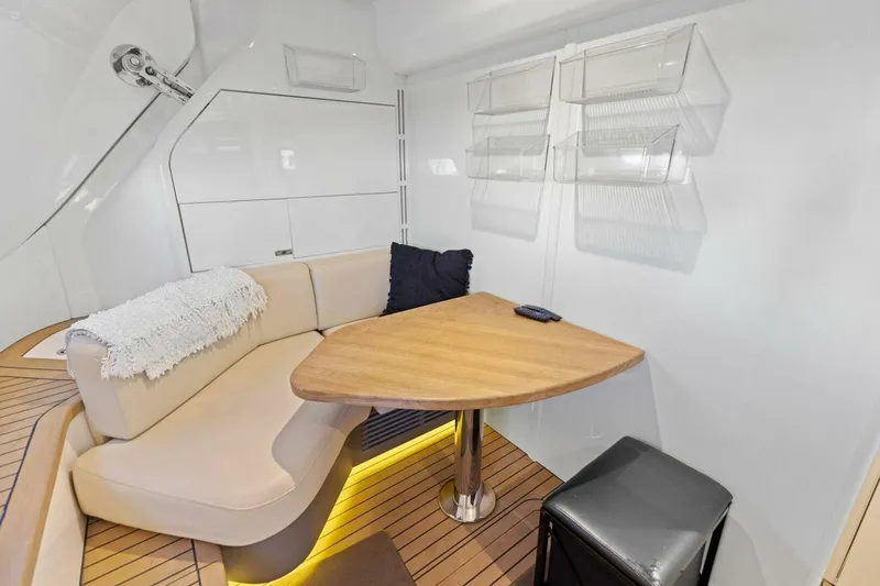 Lady Lion Yacht Photos Pics Luxurious 2023 Princess X95 yacht interior with cozy seating and elegant wooden table.