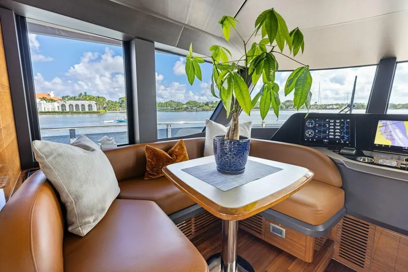 Lady Lion Yacht Photos Pics Luxurious 2023 Princess X95 yacht interior with leather seating, potted plant, and scenic water view.