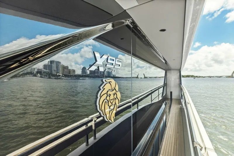 Lady Lion Yacht Photos Pics 2023 Princess X95 yacht reflecting cityscape on water, showcasing luxury design.