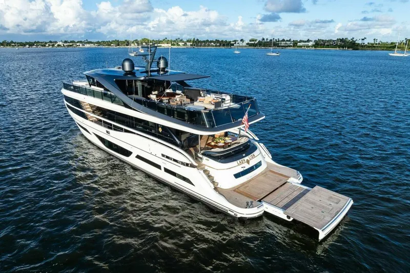 Lady Lion Yacht Photos Pics Luxurious 2023 Princess X95 yacht cruising on serene blue waters under a partly cloudy sky.