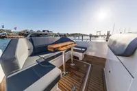 2023 Nimbus T9 X-Edition boat interior with sleek seating and wooden deck, under clear sky.