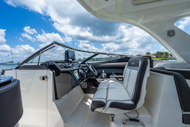  Yacht Photos Pics 2017 Sea Ray 31 SLX boat interior with helm and seating, under a blue sky.