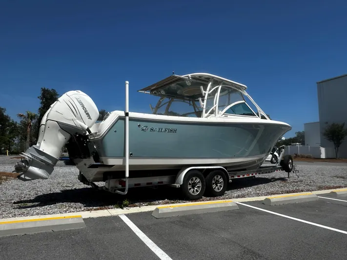  Yacht Photos Pics 2018 Sailfish 325DC boat on trailer, parked in a lot under clear blue sky.
